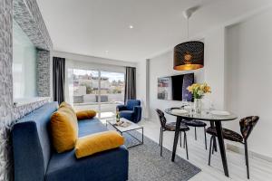 a living room with a blue couch and a table at BAL Apartments Adults Only in Arona