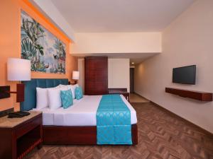 Cette chambre comprend un lit et une télévision à écran plat. dans l'établissement Daiwik Hotels Rameswaram, à Rameswaram