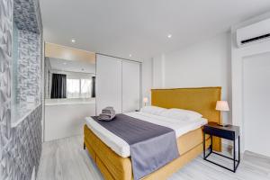 a bedroom with a large bed and a bathroom at BAL Apartments Adults Only in Arona