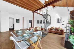 a living room with a glass table and white chairs at Large Industrial Style 2 Bedroom Flat! in London
