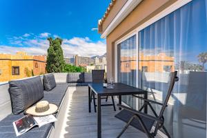 eine Terrasse mit einem Tisch und Stühlen auf dem Balkon in der Unterkunft BAL Apartments Adults Only in Arona