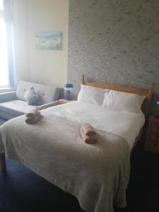 a bedroom with a bed with two towels on it at Camelot Seafront Hotel in Blackpool