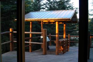 a wooden gazebo with a roof on a deck at Wise Old Hunter Lodge in Anchor Point