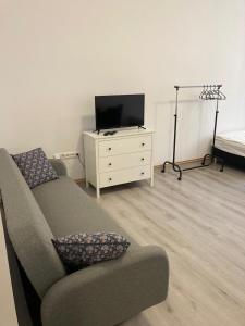 a living room with a couch and a tv and a dresser at Apartmány na Trojce in Žatec