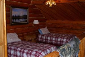 a room with two beds in a log cabin at Wise Old Hunter Lodge in Anchor Point