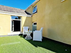 a patio with two white chairs and a table at The Cruck in Preston