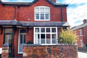 ein rotes Backsteinhaus mit einem weißen Fenster in der Unterkunft Shrewsbury Townhouse - Free Parking in Shrewsbury