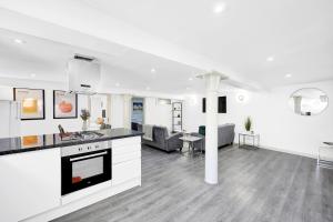 an open kitchen and living room with white walls at Cool 2 Bed Basement Flat in Central Shoreditch! in London