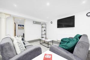 a living room with two couches and a flat screen tv at Cool 2 Bed Basement Flat in Central Shoreditch! in London