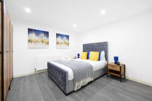a bedroom with a bed and two paintings on the wall at Cool 2 Bed Basement Flat in Central Shoreditch! in London