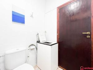 La salle de bains est pourvue de toilettes et d'une porte marron. dans l'établissement Oasis a 50m del Mar, à Grao de Castellón