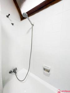 d'une douche avec un tuyau fixé à une baignoire blanche. dans l'établissement Oasis a 50m del Mar, à Grao de Castellón
