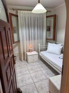 um quarto com uma cama e uma mesa com um candeeiro em Ωραίο διαμέρισμα κοντά στο μετρό em Atenas