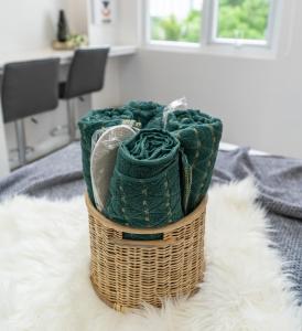 a basket filled with green towels on a bed at Kalani by J&J (Symfoni Nichols. Pool. Netflix) in Cebu City +14 photos
