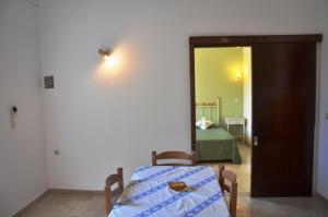 a room with a table and a bed and a mirror at Taxi Driver Apartments in Paleokastritsa