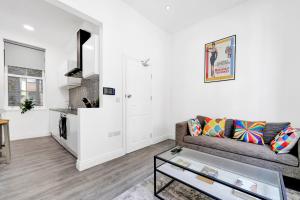 uma sala de estar com um sofá e uma mesa em Central Hoxton High Spec 2 Bed! em Londres