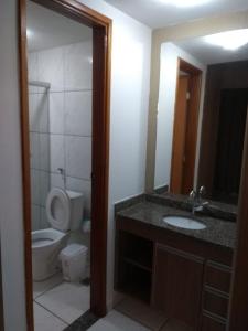 a bathroom with a toilet and a sink and a mirror at Flat 111 Mont Blanc Caldas Novas LEIA ATENTAMENTE O ANUNCIO in Caldas Novas