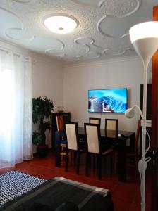 a living room with a table and a tv on a ceiling at Inviting 2-Bed Apartment in Nazare in Nazaré