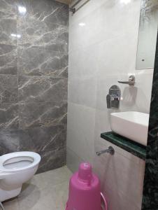 a bathroom with a white toilet and a sink at Ayala PG Dormitory in Mumbai