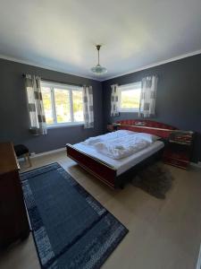 a bedroom with a bed and a blue wall at Leitane 2 Bremanger in Fossane