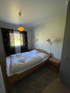 a bedroom with a large bed and a window at Leitane 2 Bremanger in Fossane