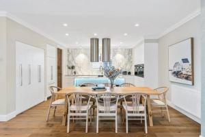a kitchen and dining room with a table and chairs at Spacious Luxury Hampton Home - Park Front in Melbourne