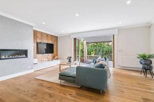 ein Wohnzimmer mit einem Sofa und einem Kamin in der Unterkunft Spacious Luxury Hampton Home - Park Front in Melbourne