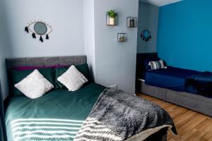 a bedroom with a green bed with a mirror on the wall at Emerald Gem of Leeds with Great Location including Parking in Killingbeck