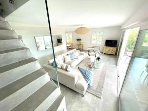 ein Wohnzimmer mit einer weißen Couch und einer Treppe in der Unterkunft Villa 250m² avec studio Vue Mer in La Croix-Valmer