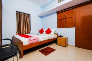 a bedroom with a bed with red pillows at OYO Flagship Adam's Bridge International Hotel in Patna