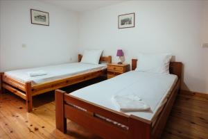 two beds in a room with wooden floors at Dimitra Apartments in Kandia