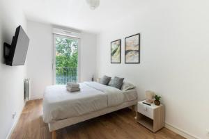 a white bedroom with a bed and a window at StadeDeFrance/Saint-Denis : Appartement Terrasse 6P in Saint-Denis