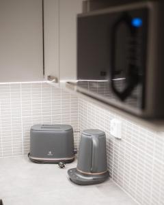 ロヴァニエミにあるApartment Mallaのキッチンカウンターに電子レンジとトースター2台