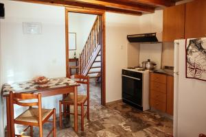 a kitchen with a table and a stove top oven at Dimitra Apartments in Kandia +32 photos