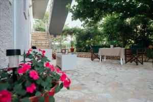 a patio with a table and some pink flowers at Dimitra Apartments in Kandia