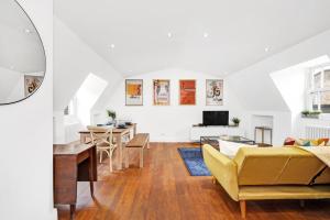 a living room with a yellow couch and a table at Loft apartment in Broadway Market in London