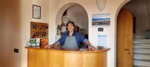 Una donna in piedi dietro un bancone in un bar di Villa San Biagio a Mason Vicento