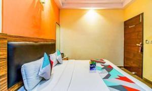 a bed in a room with an orange wall at FabExpress JP Palace in New Delhi