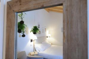 a bedroom with a bed and two plants on the wall at Montegusto in Castel del Monte