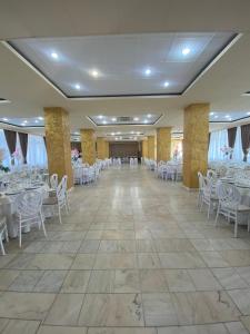 a banquet hall with white chairs and tables at Hotel Diana in Bistriţa