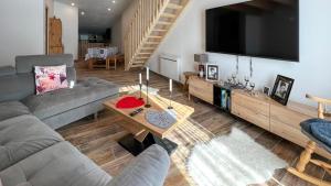 ein Wohnzimmer mit einem Sofa und einem TV in der Unterkunft Le Super Refuge de l'Ecureuil in Enchastrayes