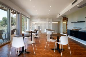 una sala da pranzo con tavoli e sedie bianche di AGRITURISMO TERRA VOLONTERI a Montecatini Terme