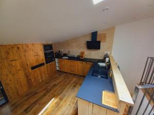 une cuisine avec des placards en bois et un comptoir bleu dans l'établissement Le Super Refuge de l'Ecureuil, à Enchastrayes