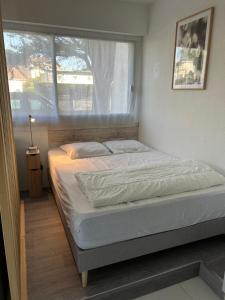 een bed in een slaapkamer met een groot raam bij LA BAULE : STUDIO MER EN REZ DE JARDIN in La Baule