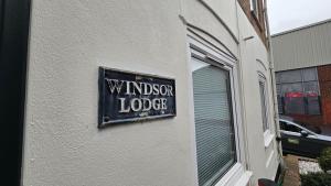 een bord aan de zijkant van een gebouw dat Wimposter Lodge leest bij The Windsor Lodge in Brighton & Hove