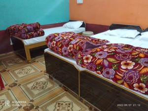 two twin beds in a room with a tiled floor at Kedarnath Tent Prithvi yatra Hotel in Kedārnāth