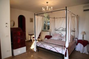 1 dormitorio con cama con dosel y lámpara de araña en B&B H.M., en Sonnino