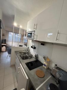 een keuken met een spoelbak en een fornuis bovenste oven bij LA BAULE : STUDIO MER EN REZ DE JARDIN in La Baule +15 foto's