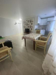 ein Wohnzimmer mit einem Tisch und Stühlen sowie eine Küche in der Unterkunft Happy home Narimanov in Baku