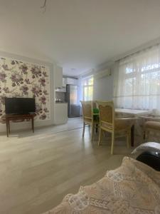 ein Wohnzimmer mit einem TV, einem Tisch und Stühlen in der Unterkunft Happy home Narimanov in Baku